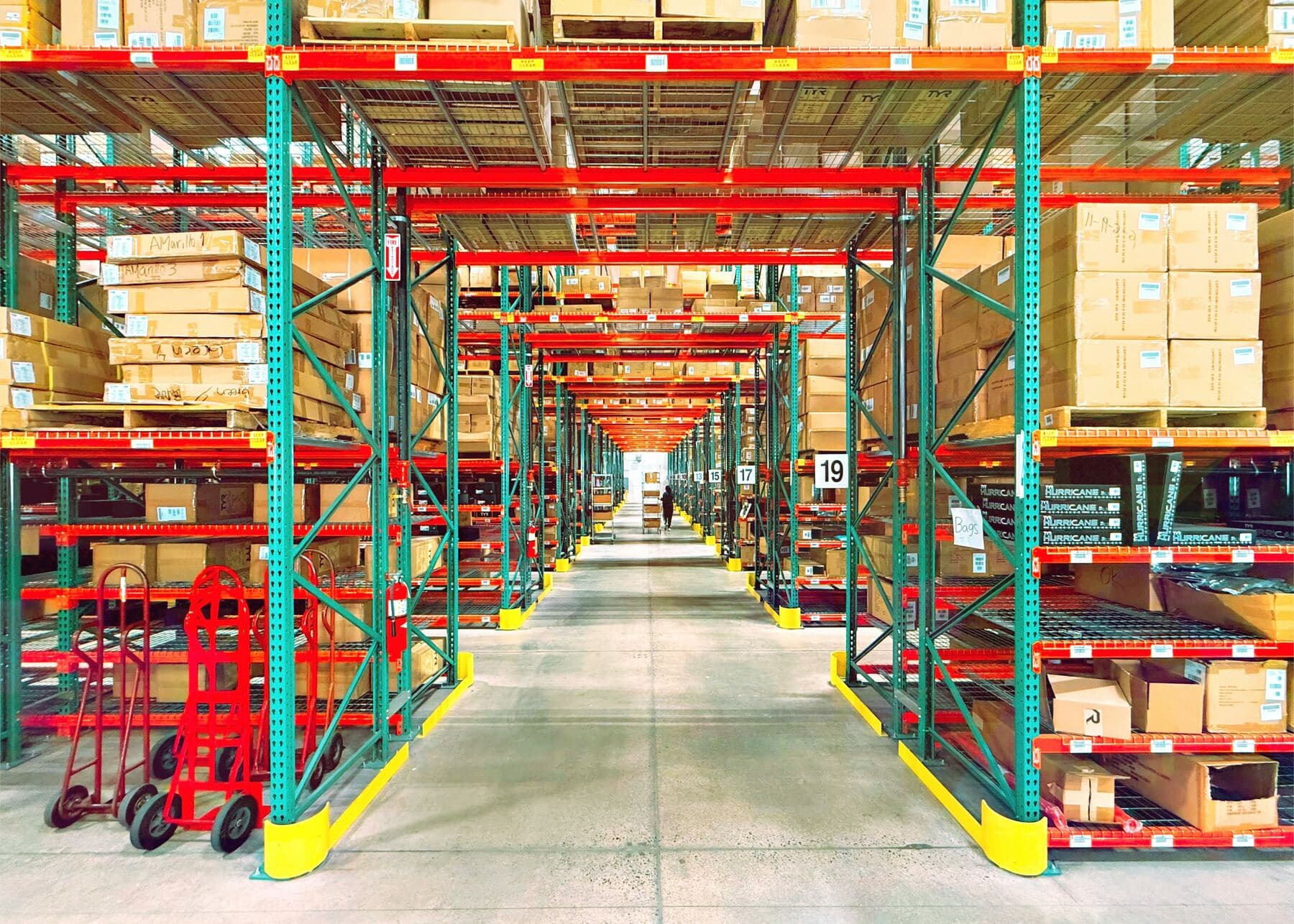High-bay warehouse with pallets in long rows of racks